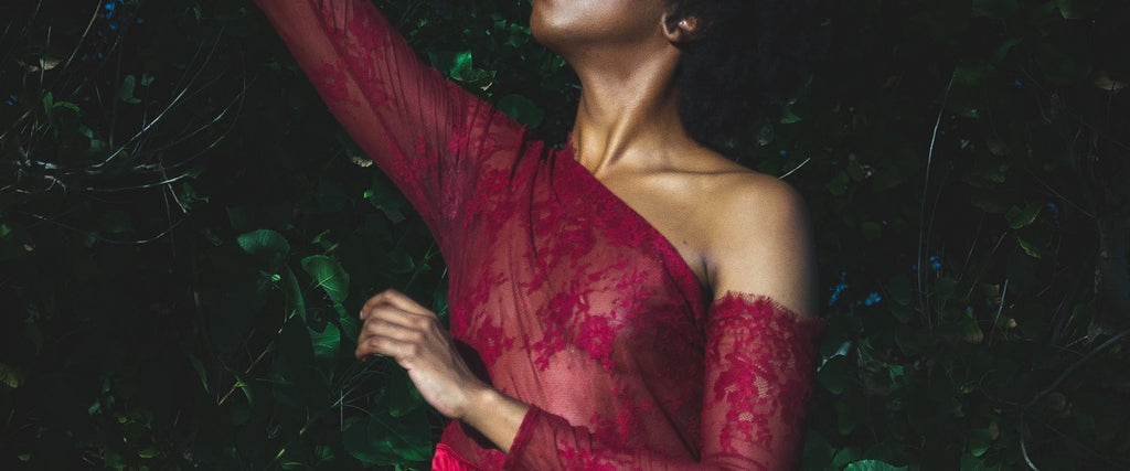 A woman in a red lace Body with long arms